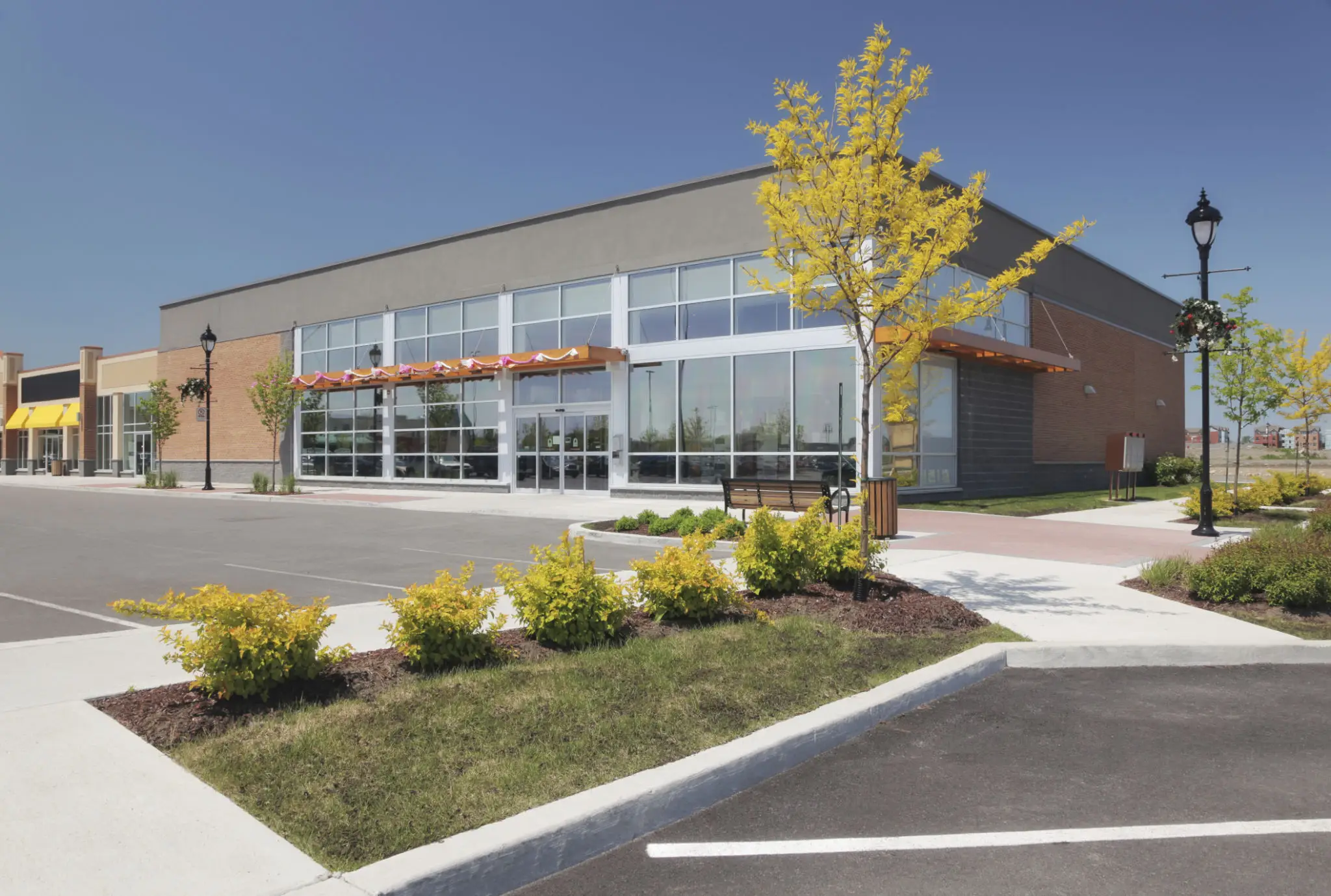 Modern commercial building with glass facade and landscaped surroundings.