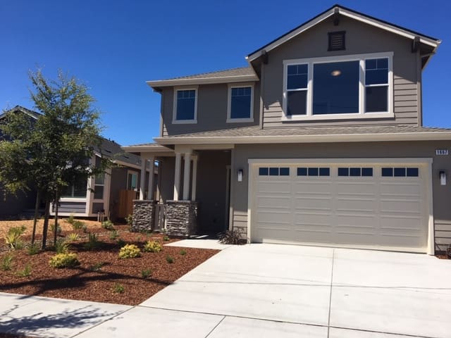 Modern two-story house with a spacious driveway and garage.